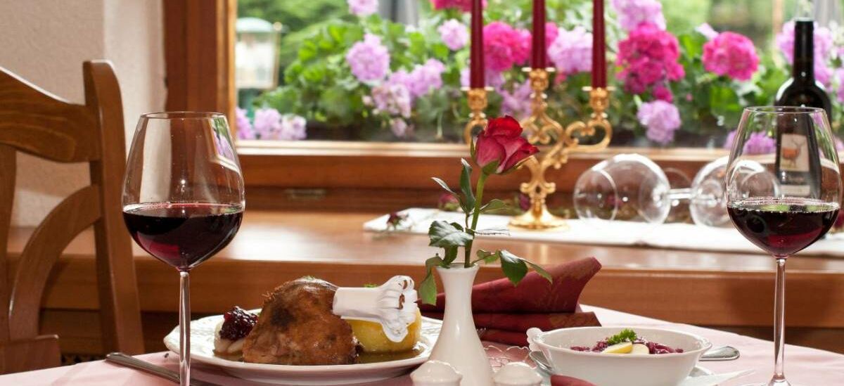Gedeckter Tisch im Waldhotel Rennsteighof mit Rotwein, Gänsekeule und Thüringer Klößen