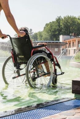 Nichtschwimmerbereich im Freibad BioBad Glücksbrunn mit barrierefreiem Beckeneinstieg und Kind im Rollstuhl